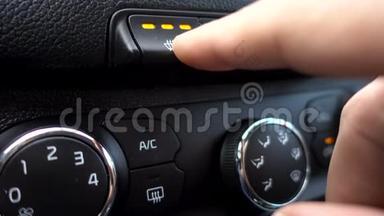 汽车按钮中的加热座椅。 特写镜头。 汽车座椅仪表盘加热。